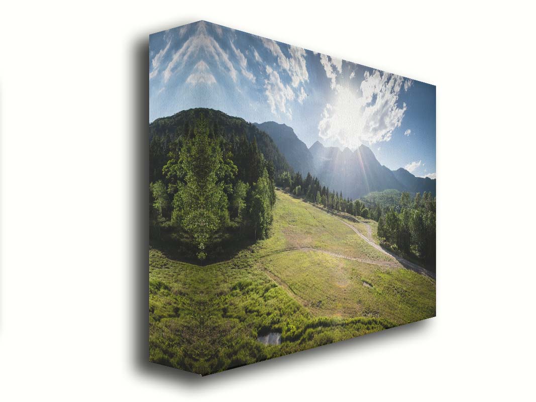 A photo of the sun shining brightly over Mount Timpanogos. The hillsides and forest are the fresh green of springtime. Printed on canvas.