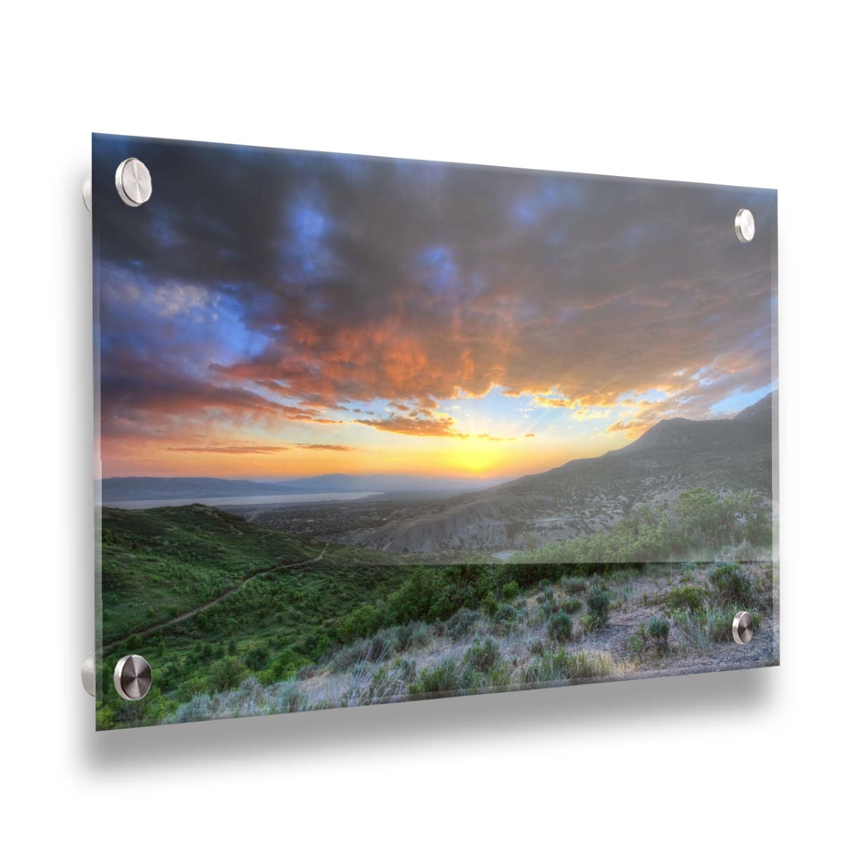 A photo of the sunset at Piestewa Peak in Provo Canyon, Utah. The gold light from the sun reflects off gray clouds about the green foliage surrounding the mountain. Printed on acrylic.