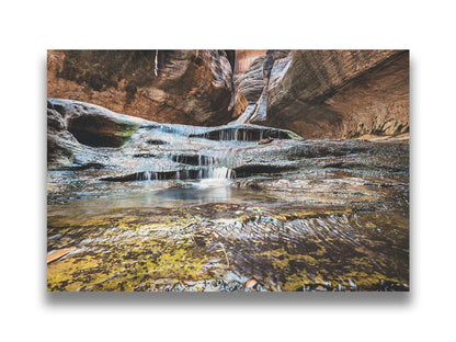 A photo of the Left Fork North Creek flowing through the Subway slot canyon in Utah's Zion National Park. It flows toward the camera, tumbling over slabs in the sandstone to create small waterfalls. Printed on canvas.