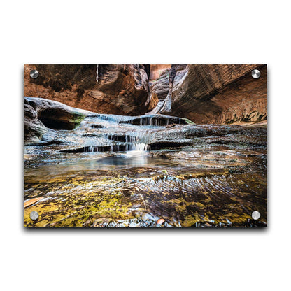 A photo of the Left Fork North Creek flowing through the Subway slot canyon in Utah's Zion National Park. It flows toward the camera, tumbling over slabs in the sandstone to create small waterfalls. Printed on acrylic.