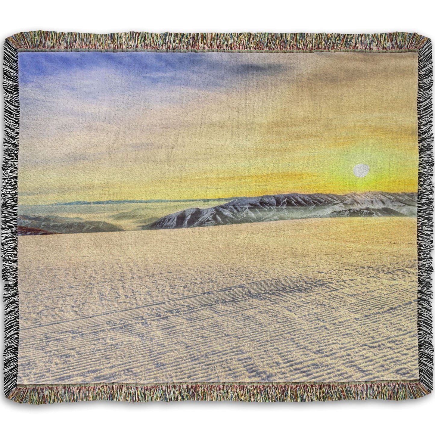 A woven throw blanket designed with a photo of the sunrise over a freshly groomed ski slope at Sundance Ski Resort.