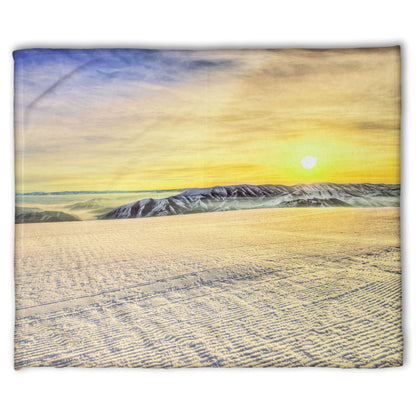 A coral fleece blanket designed with a photo of the sunrise over a freshly groomed ski slope at Sundance Ski Resort.