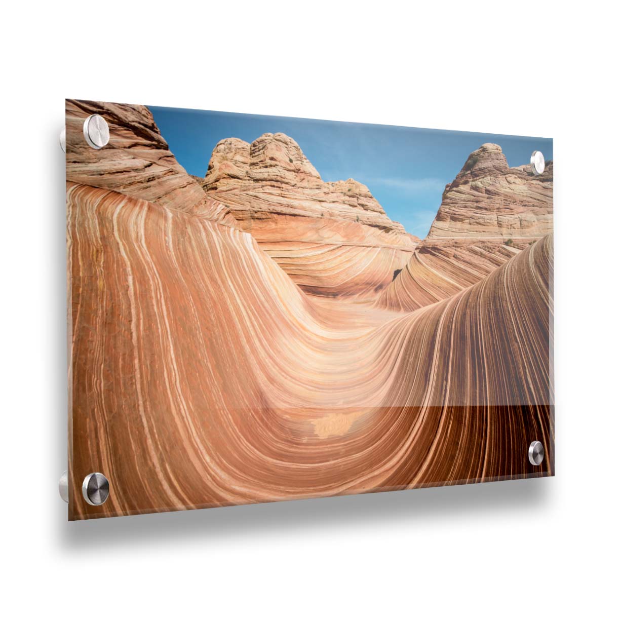 A photo of the "Wave" rock formation at Coyote Buttes North in Utah. The wavy sandstone layers create rolling waves where they have been carved out of the mountainside. The orange hues of the stone are sharply contrasted by the vibrant blue of the sky. Printed on acrylic.