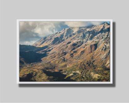 A photo of Mount Timpanogos during the fall. Taken from Piestewa Peak, this photo looks down across groves of trees turning color, appearing small from the altitude. Printed on canvas in a float frame.