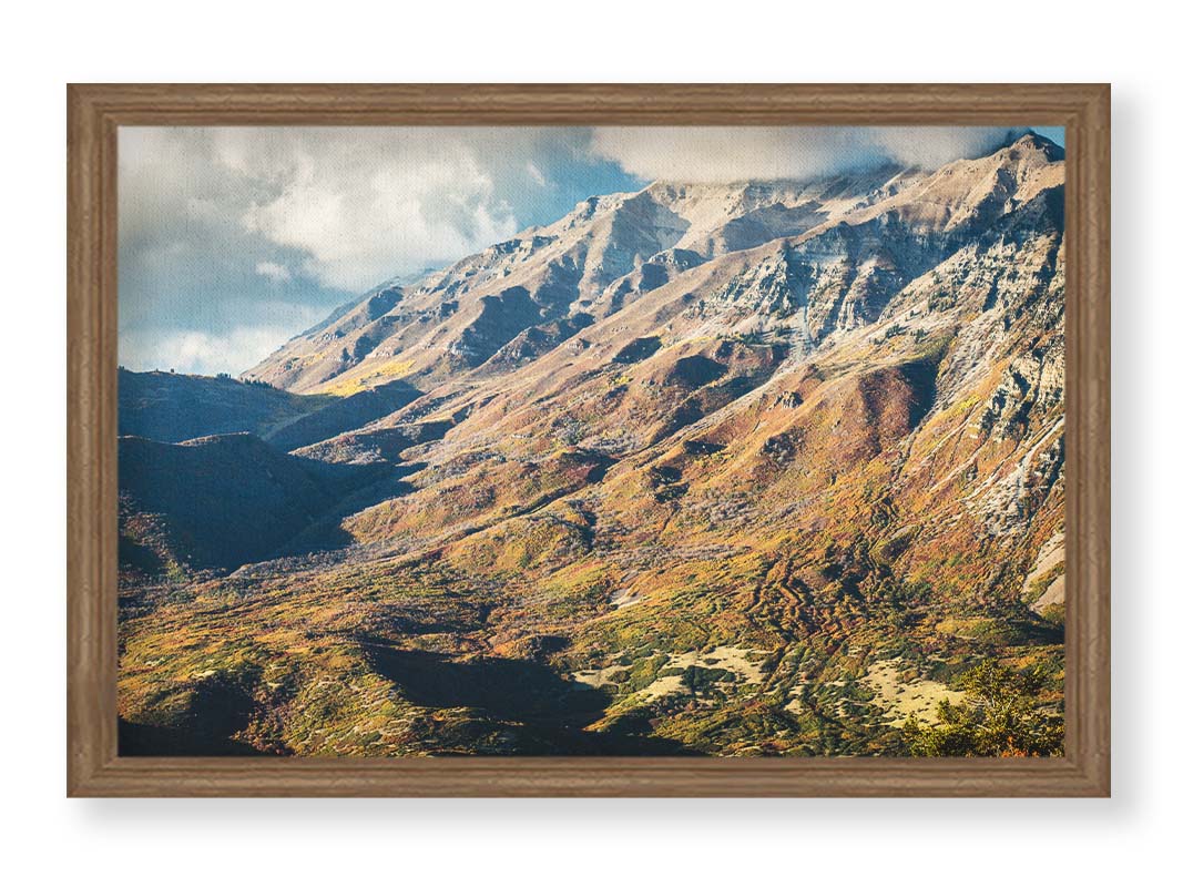 A photo of Mount Timpanogos during the fall. Taken from Piestewa Peak, this photo looks down across groves of trees turning color, appearing small from the altitude. Printed on canvas and framed.