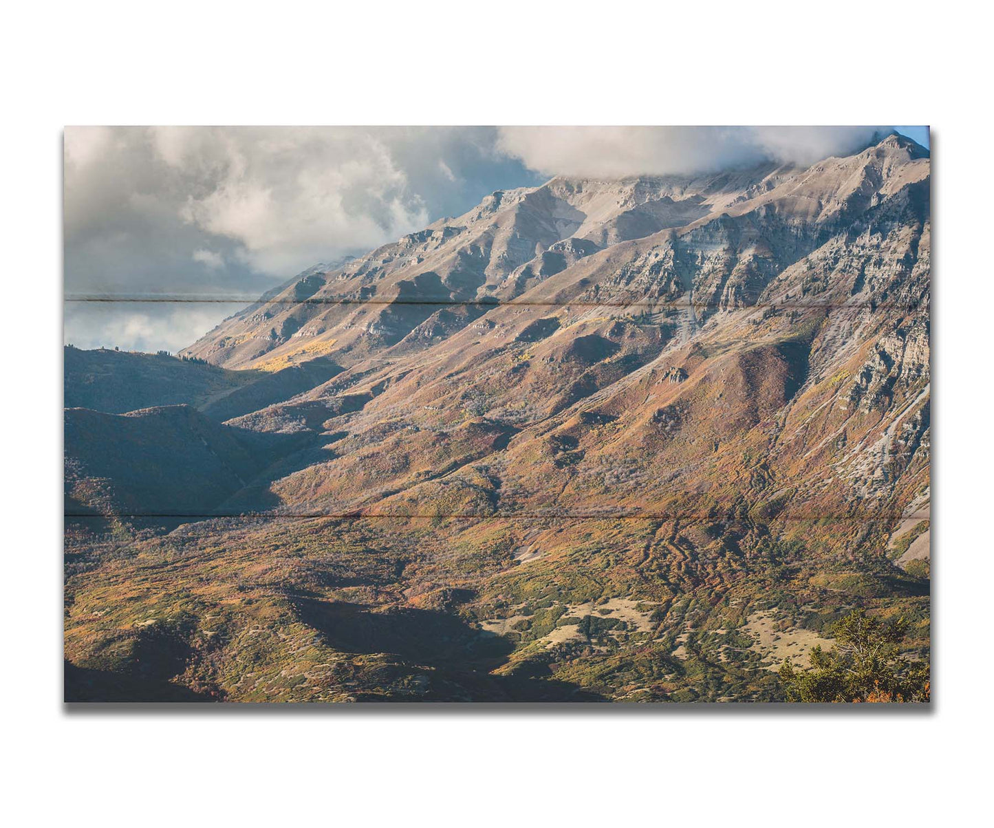 A photo of Mount Timpanogos during the fall. Taken from Piestewa Peak, this photo looks down across groves of trees turning color, appearing small from the altitude. Printed on a box board.