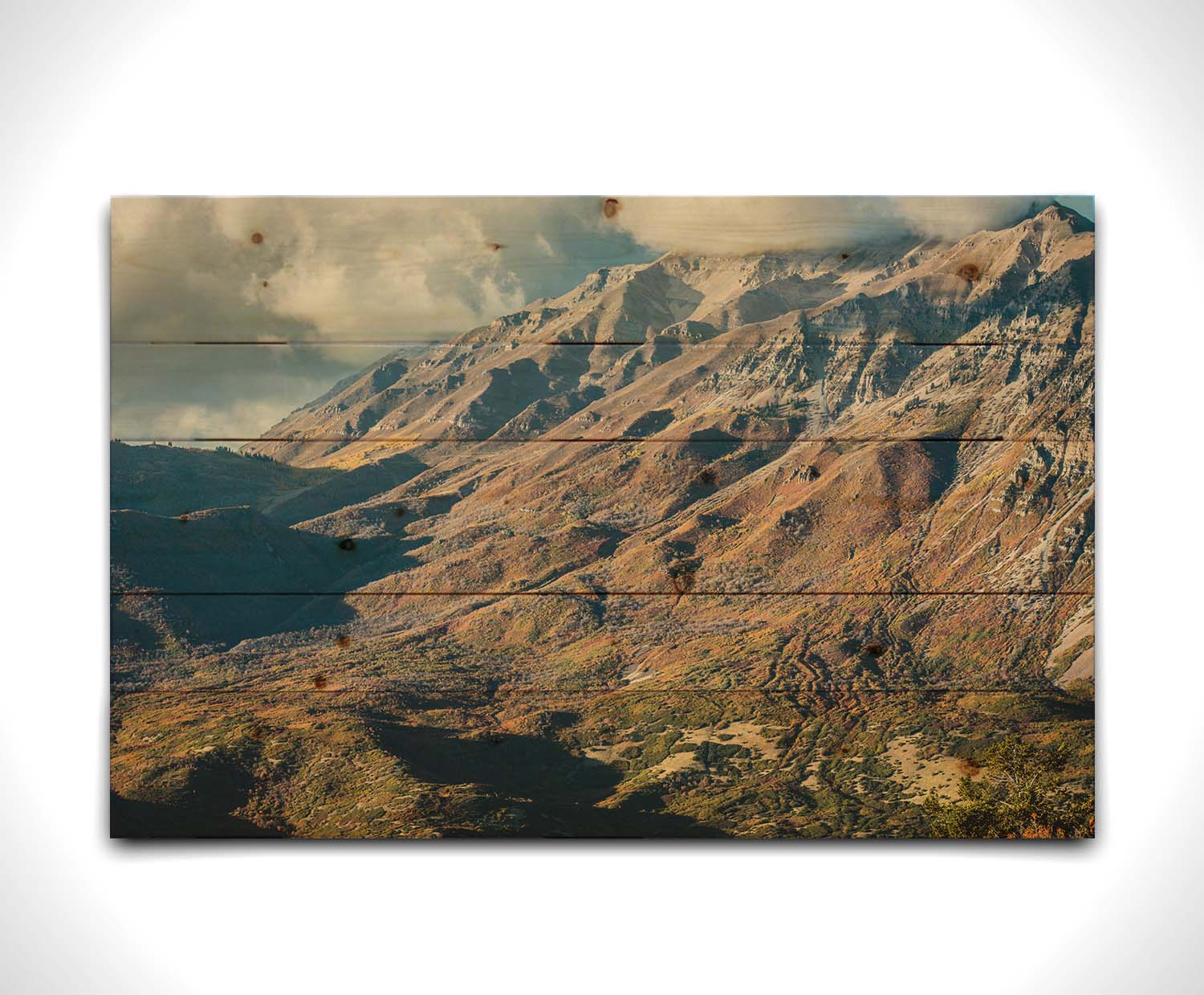 A photo of Mount Timpanogos during the fall. Taken from Piestewa Peak, this photo looks down across groves of trees turning color, appearing small from the altitude. Printed on a wood pallet.