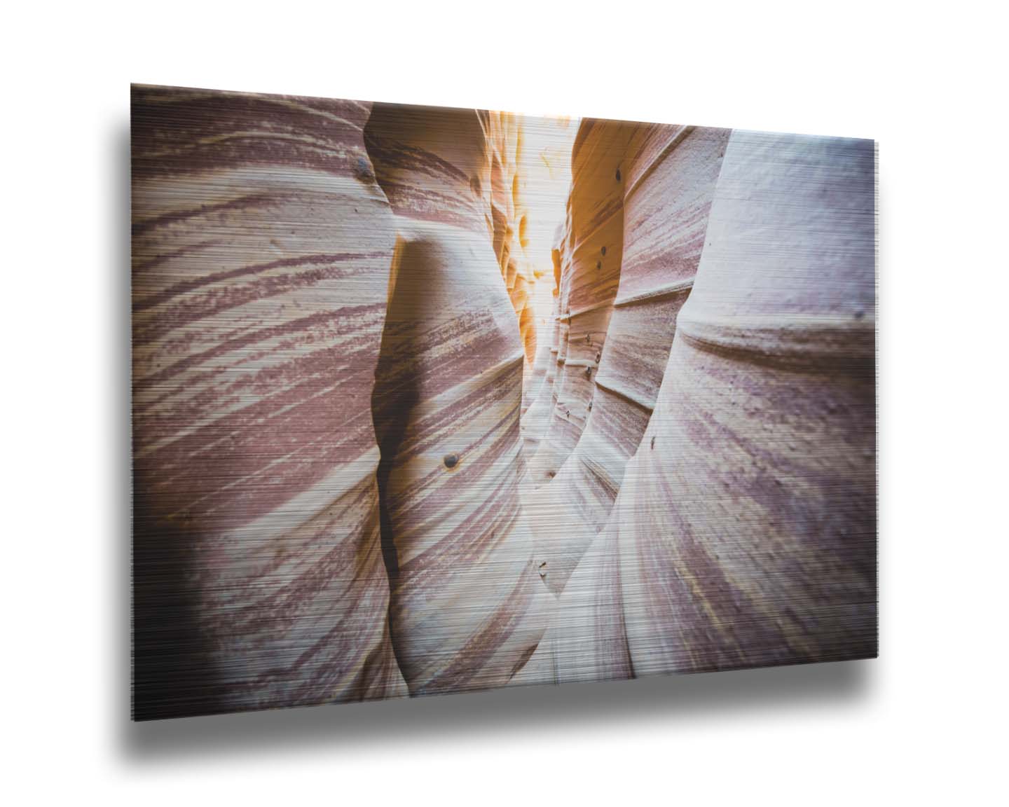 A photo of Zebra Slot Canyon in Escalante National Monument, Utah. A tight formation of alternating, red and white striped stone walls wave into the distance, where yellow light can be seen. Printed on metal.