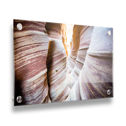 A photo of Zebra Slot Canyon in Escalante National Monument, Utah. A tight formation of alternating, red and white striped stone walls wave into the distance, where yellow light can be seen. Printed on acrylic.