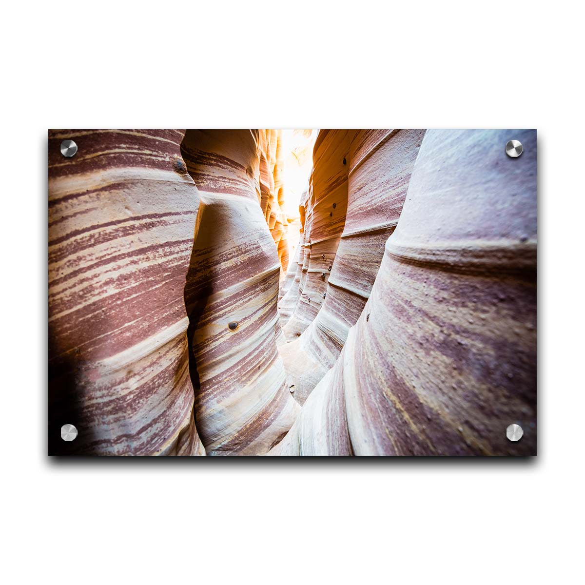 A photo of Zebra Slot Canyon in Escalante National Monument, Utah. A tight formation of alternating, red and white striped stone walls wave into the distance, where yellow light can be seen. Printed on acrylic.