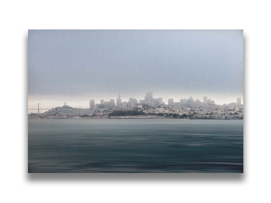 A photo of San Francisco bay taken from Vista Point. The long exposure of the photo creates a smoothing effect on the dark waters, and a heavy cloud of fog site just across the top of the city on the horizon. Printed on canvas.