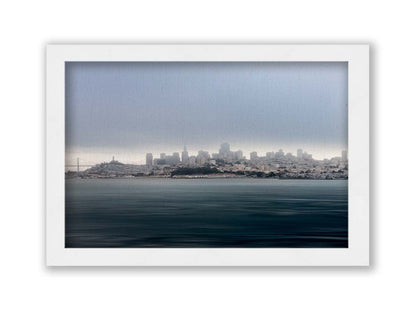 A photo of San Francisco bay taken from Vista Point. The long exposure of the photo creates a smoothing effect on the dark waters, and a heavy cloud of fog site just across the top of the city on the horizon. Printed on canvas and framed.