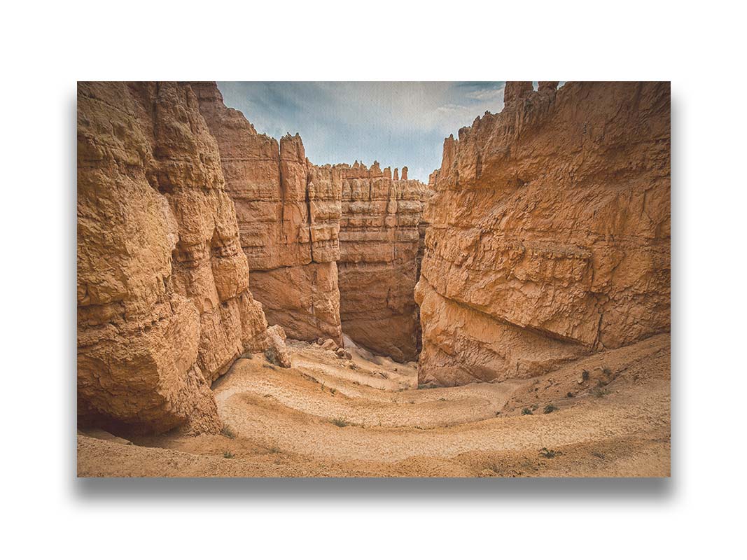 A photo of the Wall Street rock formation at Bryce Canyon National Park in Utah. The layers of stone create walls bordering a staircase-like path down through the canyon. Printed on canvas.