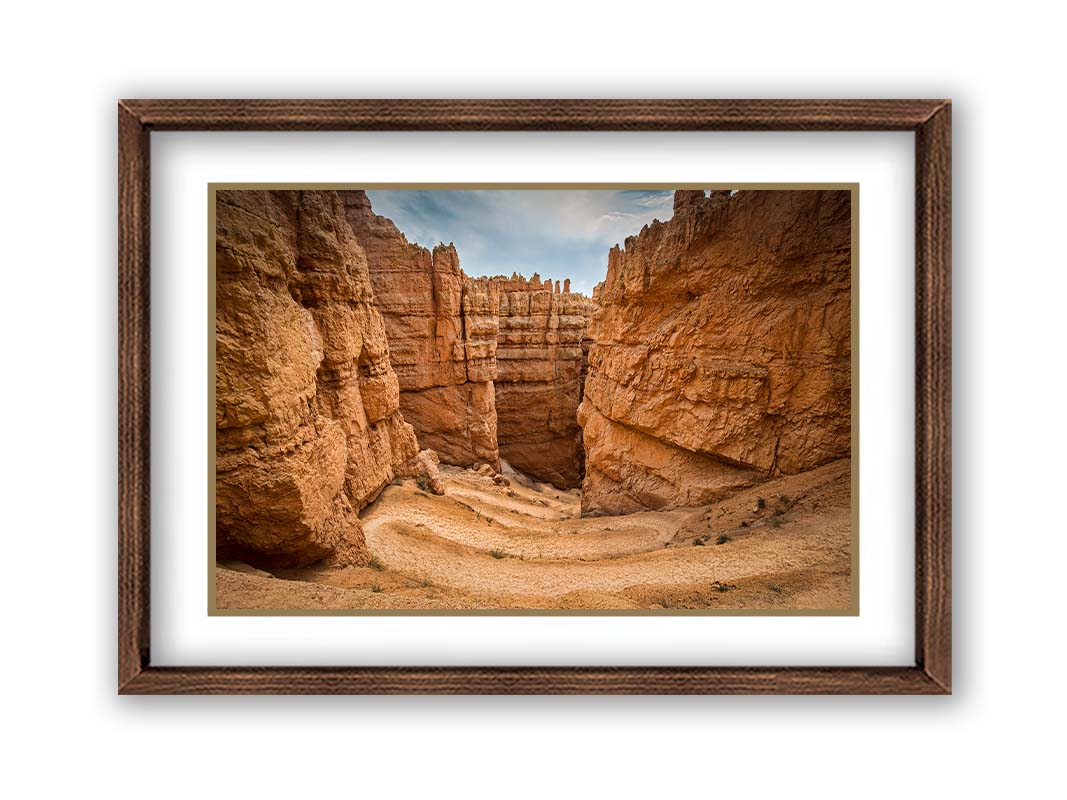 A photo of the Wall Street rock formation at Bryce Canyon National Park in Utah. The layers of stone create walls bordering a staircase-like path down through the canyon. Printed on paper, matted, and framed.