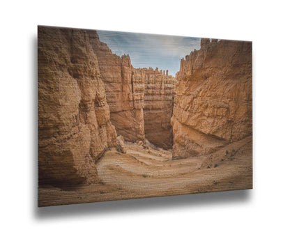 A photo of the Wall Street rock formation at Bryce Canyon National Park in Utah. The layers of stone create walls bordering a staircase-like path down through the canyon. Printed on metal.