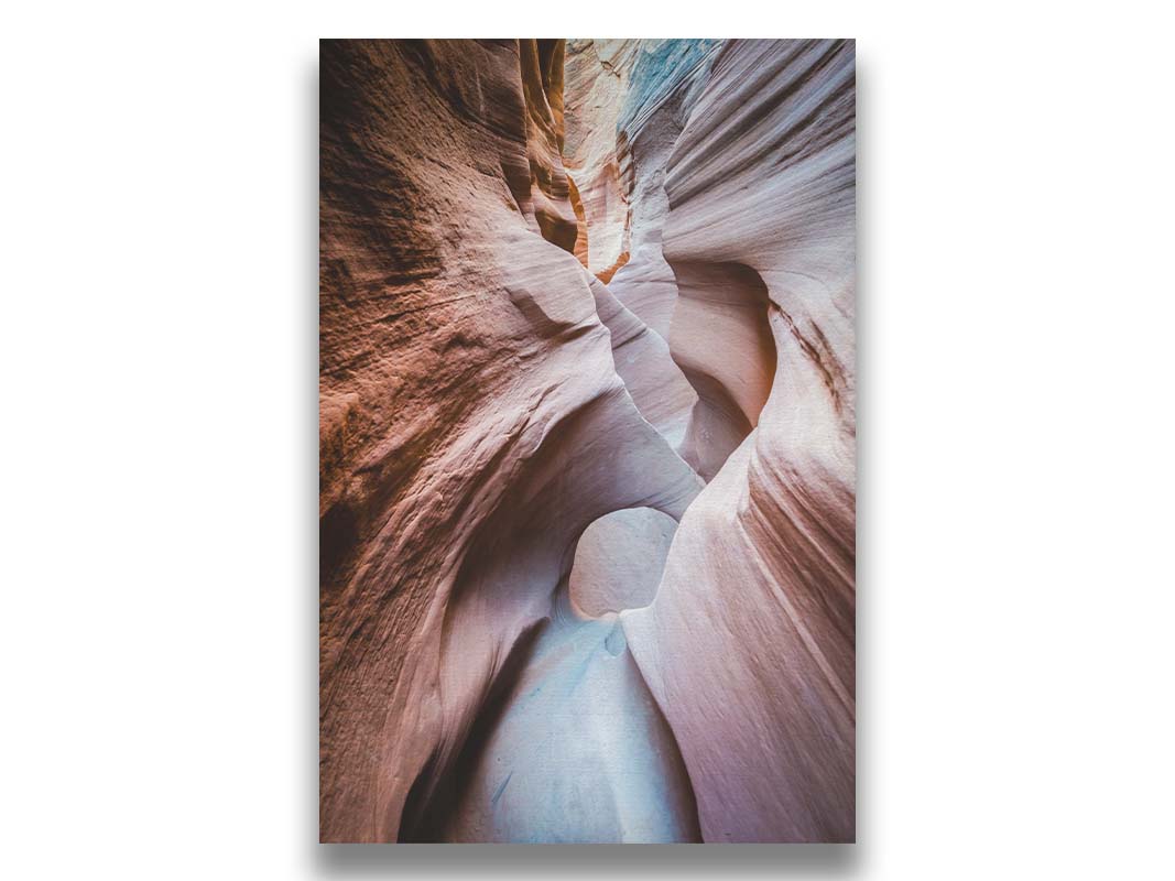 A photo looking through Peek-A-Boo slot canyon near Escalante, Utah. The wavy layers of sandstone have an unusual, surreal appearance. Printed on canvas.