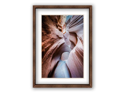 A photo looking through Peek-A-Boo slot canyon near Escalante, Utah. The wavy layers of sandstone have an unusual, surreal appearance. Printed on paper, matted, and framed.