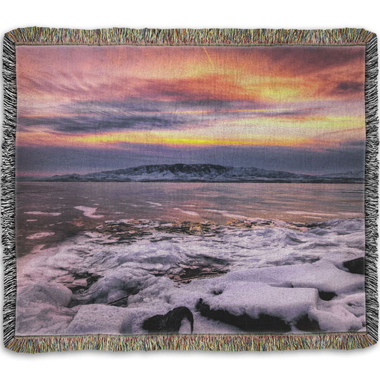 A woven throw blanket designed with the photo of a sunset over an icy lake at Mount Timpanogos, Utah, one Christmas evening.