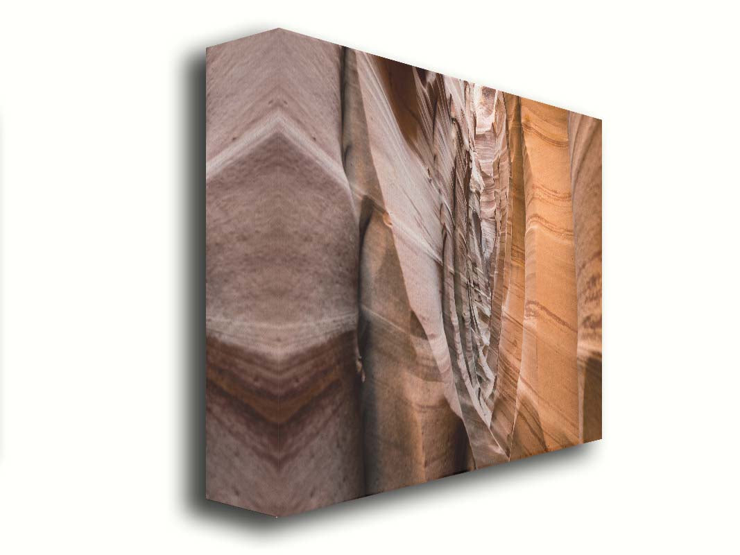 A photo of the Zebra Slot Canyon at Grand Staircase-Escalante National Monument, Utah. The red and orange sandstone stripes alternate in sharp waves down the length of the narrow passageway. Printed on canvas.