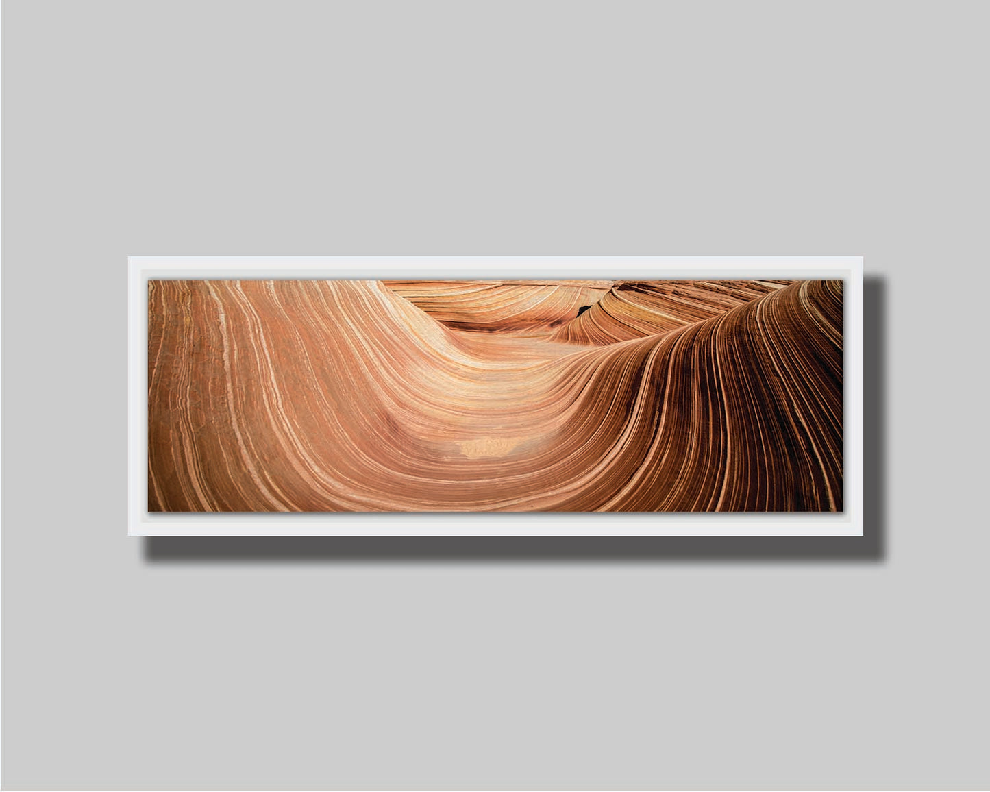 A panoramic photo of the Wave rock formation, at the Coyote Buttes North area of the Utah-Arizona border. The stripes of reddish-brown stone create a unique wave-like shape. Printed on canvas in a float frame.