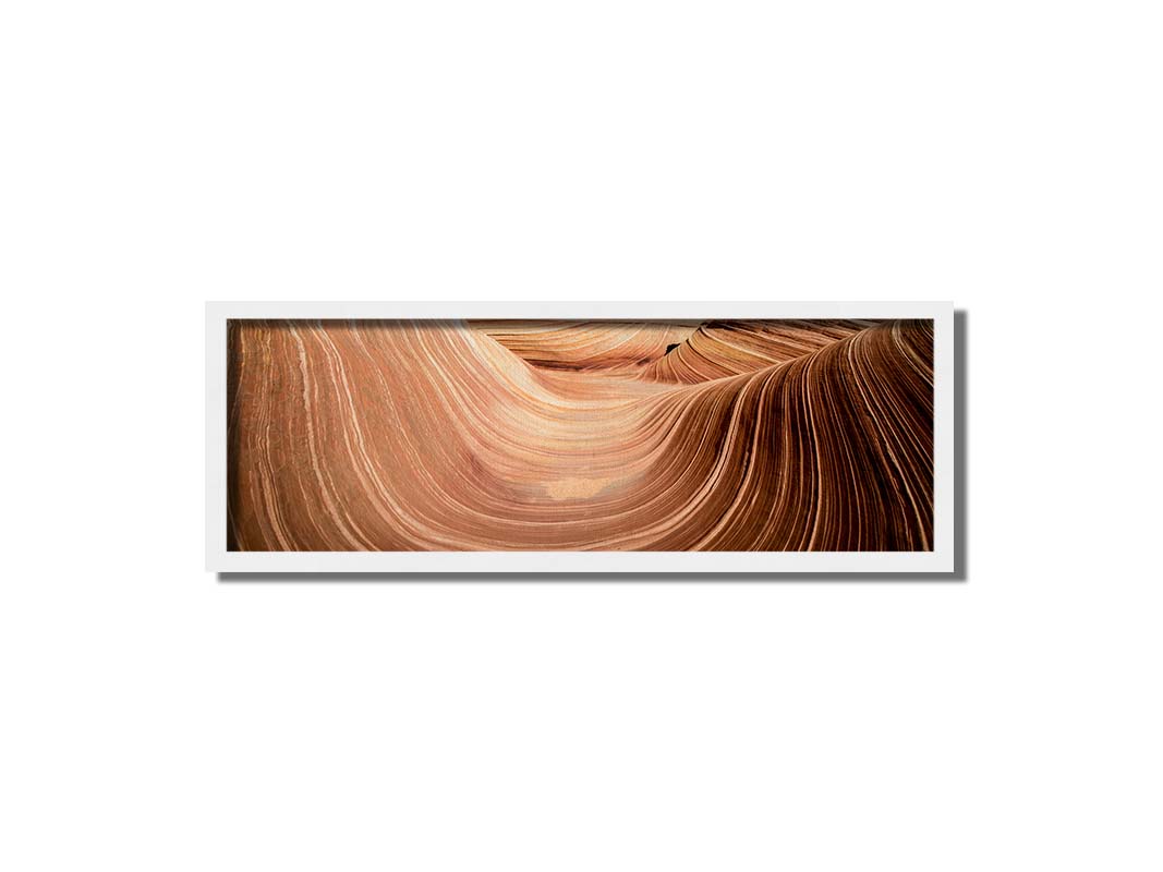 A panoramic photo of the Wave rock formation, at the Coyote Buttes North area of the Utah-Arizona border. The stripes of reddish-brown stone create a unique wave-like shape. Printed on canvas and framed.