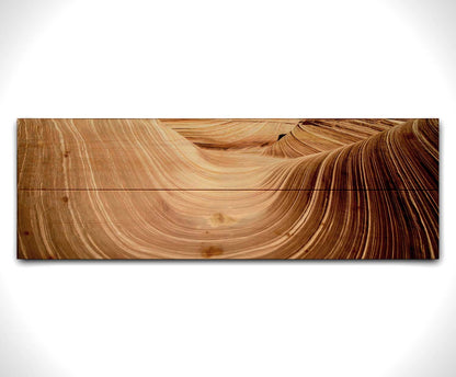 A panoramic photo of the Wave rock formation, at the Coyote Buttes North area of the Utah-Arizona border. The stripes of reddish-brown stone create a unique wave-like shape. Printed on a wood pallet.