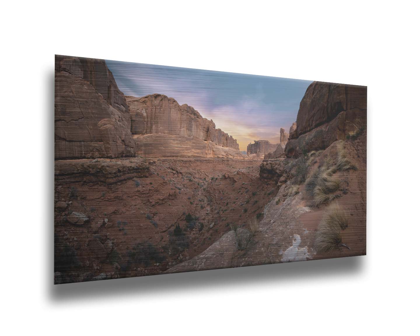 A photo from a Moab, Utah canyon. Sparse shrubbery is scattered along the canyon surrounded by sandstone walls. Printed on metal.