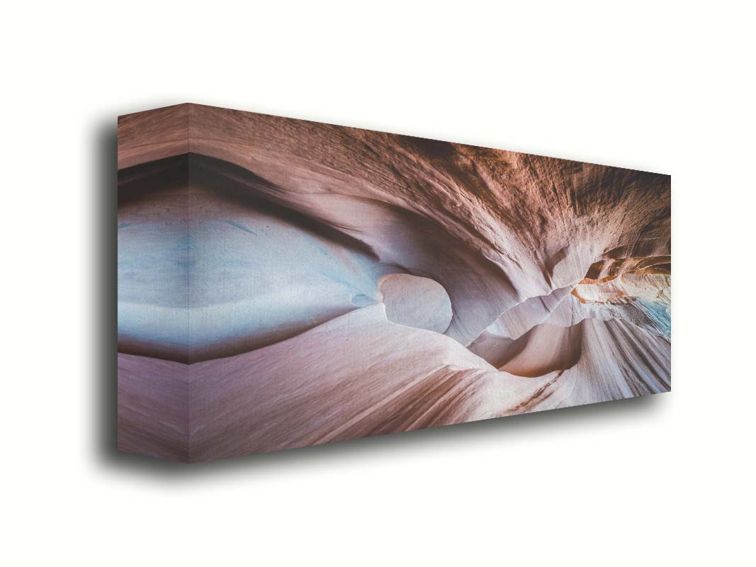 A photo looking through Peek-A-Boo slot canyon near Escalante, Utah. The wavy layers of sandstone have an unusual, surreal appearance. Printed on canvas.