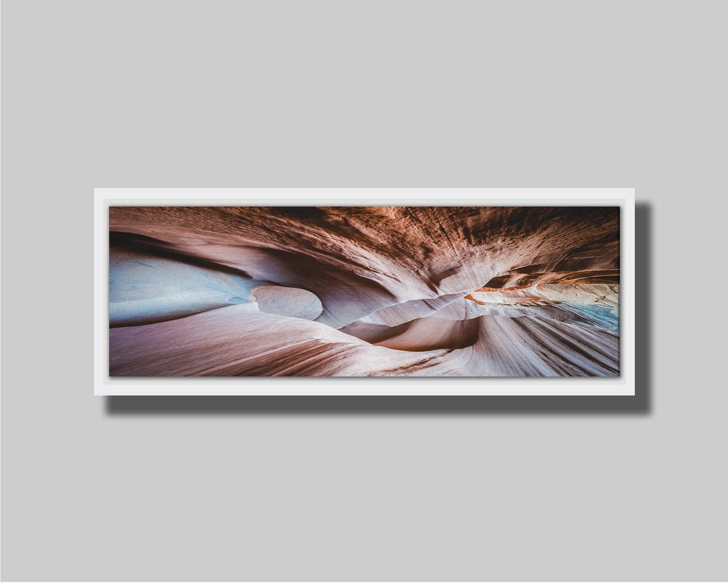 A photo looking through Peek-A-Boo slot canyon near Escalante, Utah. The wavy layers of sandstone have an unusual, surreal appearance. Printed on canvas in a float frame.