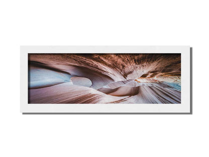 A photo looking through Peek-A-Boo slot canyon near Escalante, Utah. The wavy layers of sandstone have an unusual, surreal appearance. Printed on canvas and framed.