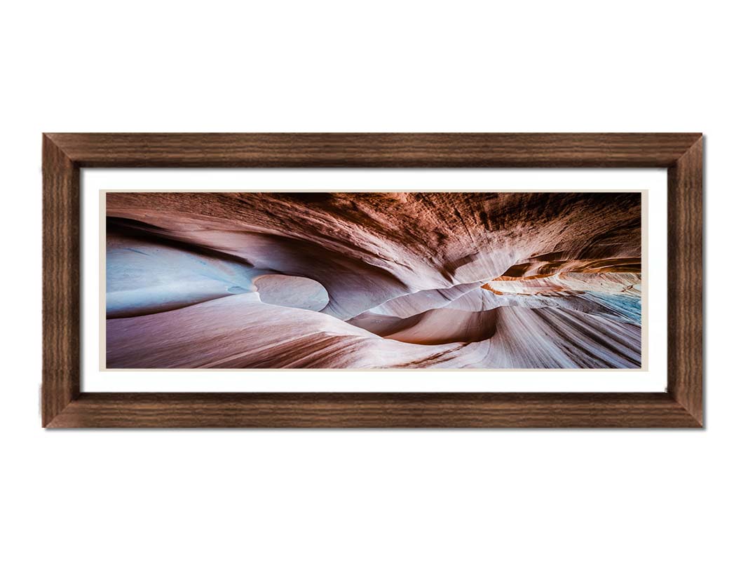 A photo looking through Peek-A-Boo slot canyon near Escalante, Utah. The wavy layers of sandstone have an unusual, surreal appearance. Printed on paper, matted, and framed.