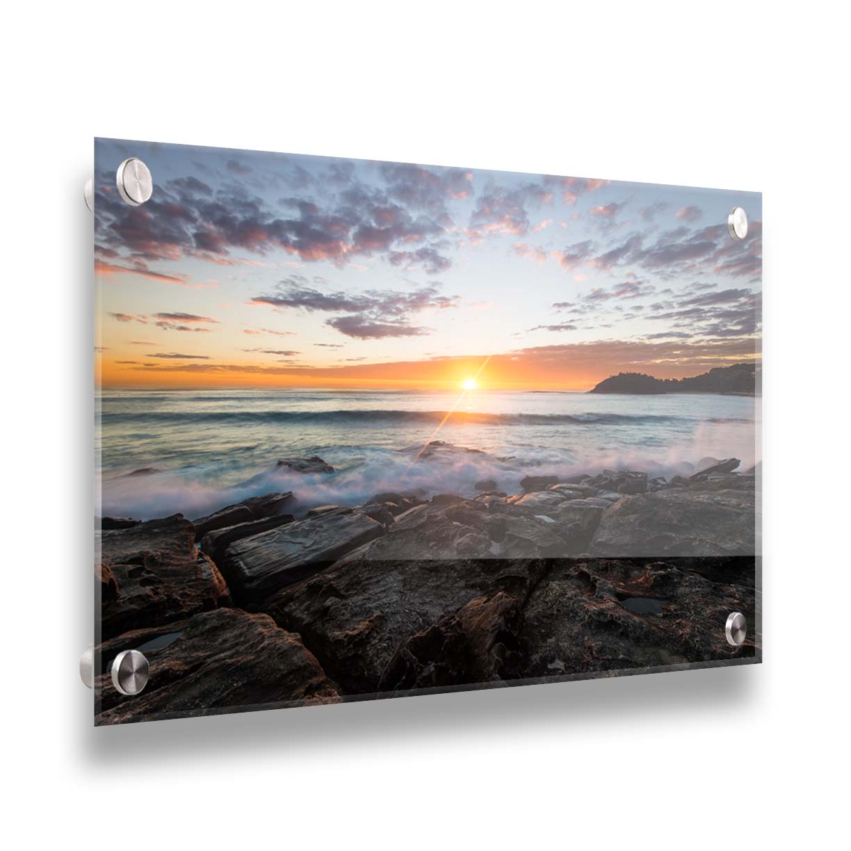 A photo of the sunrise over the ocean horizon at Manly Beach, Sydney, Australia. The sun reflecs brightly off the water as the waves splash against the rocky shore. Printed on acrylic.