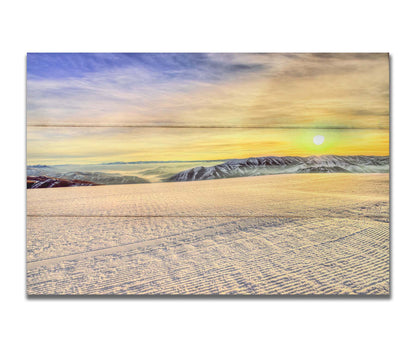 A photo of the sunrise over Sundance Ski Resort. The sun creates a yellow reflective glow on the freshly groomed ski slope. Printed on a box board.