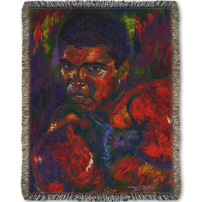 A woven throw blanket designed with a painting of boxer Muhammad Ali wearing boxing gloves in a fighting stance.