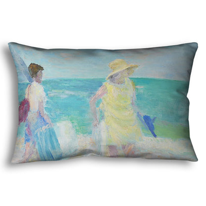 A throw pillow designed with a painting of two people on the beach, carrying towels and chairs and umbrellas. The ocean is calm behind them as they walk through the sand.