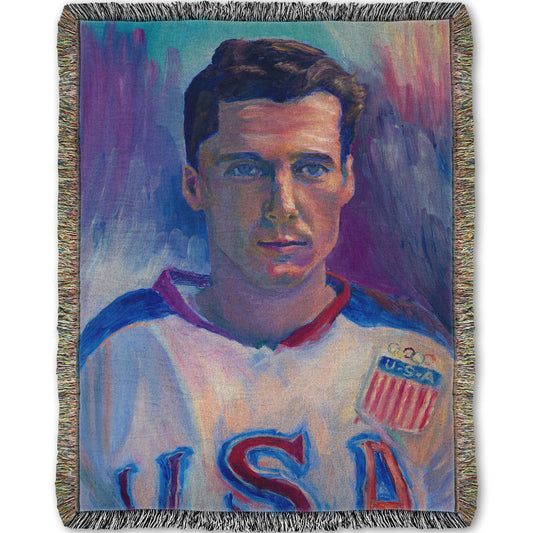 A woven throw blanket designed with a portrait painting of a United States Olympic hockey player in a cool color pallet of blues, purples, and pinks.