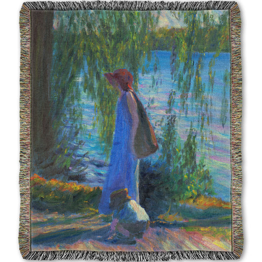 Woven throw blanket designed with a painting of a woman walking by a lake with a child, who is playing in the dirt.