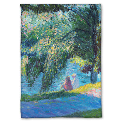 A fleece blanket designed with a painting of two people sitting by the water, near a park sidewalk, with a large tree above them.
