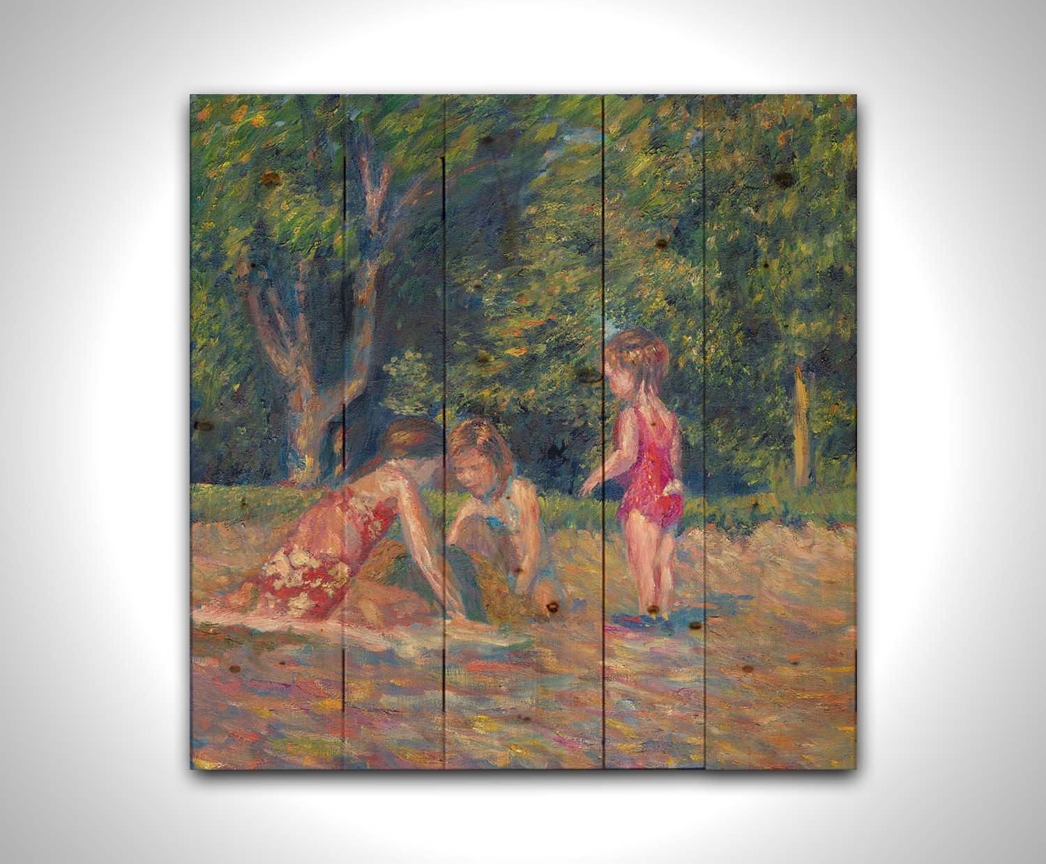 A painting of three children playing in the sand at a beach. Their red swimsuits contrast the green foliage in the background. Printed on a wood pallet.