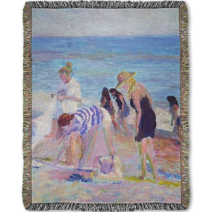 A woven throw blanket designed with a painting of beachgoers packing up their belongings after a relaxing day.
