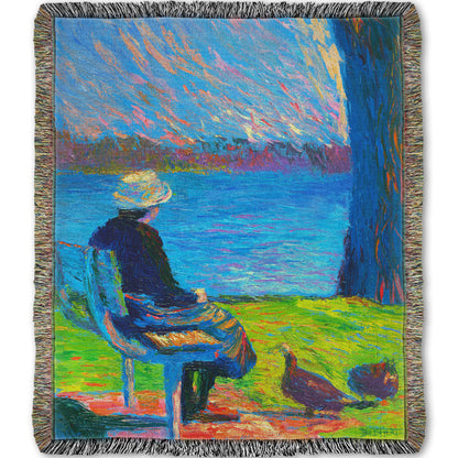 A woven throw blanket designed with a peaceful painting of a person sitting on a bench by a lake, accompanied by two ducks on the ground.