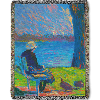 A woven throw blanket designed with a peaceful painting of a person sitting on a bench by a lake, accompanied by two ducks on the ground.