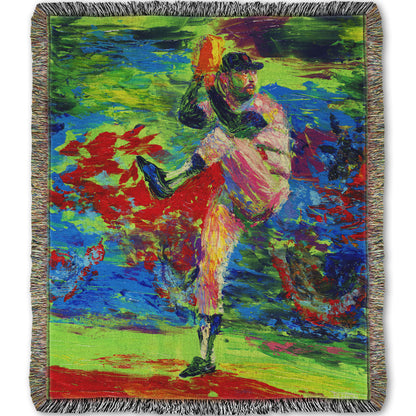 Woven throw blanket designed with a painting of a baseball pitcher preparing a throw, with a vibrant background of green, blue, and red.