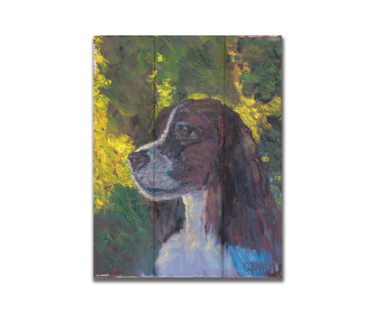 A painting of a brown and white spaniel dog, against a background of greens suggestinng foliage. Printed on a box board.