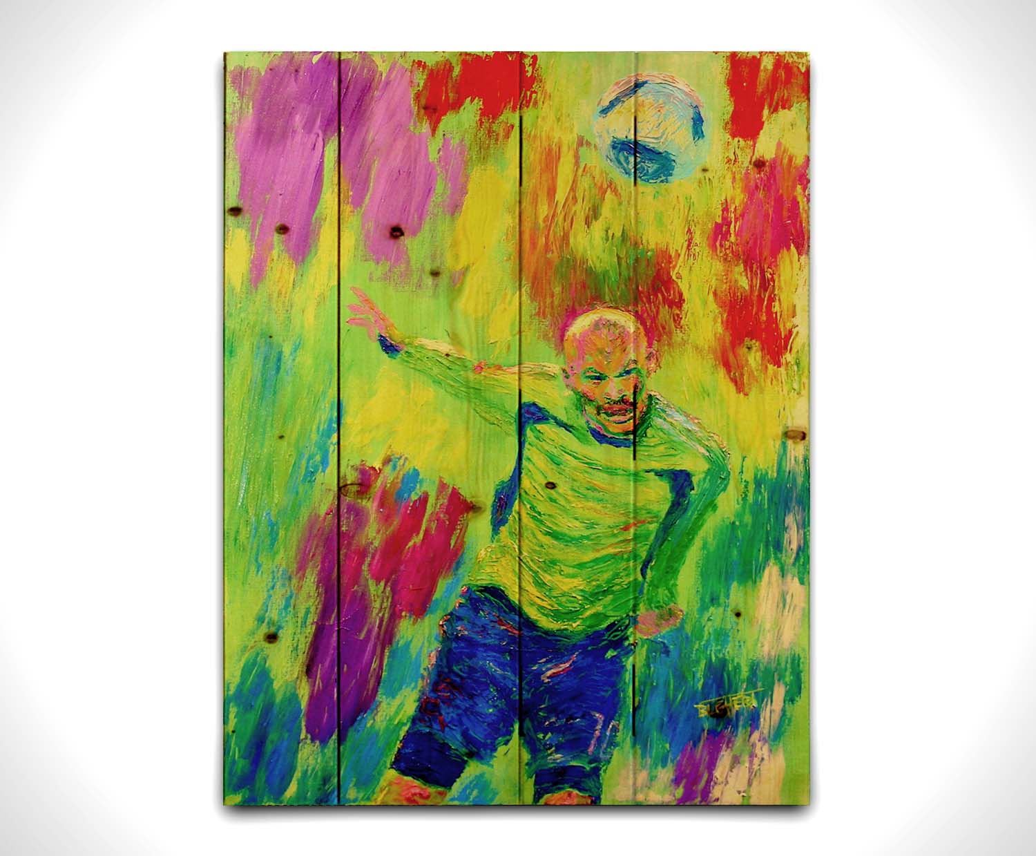 A painting of a soccer player running at a ball soaring toward them. It is painted in a bright, "neon" color palette with greens, reds, and blues. Printed on a wood pallet.