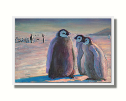 A painting of three young penguins, their colony in the background standing on the icy landscape. Printed on canvas in a float frame.