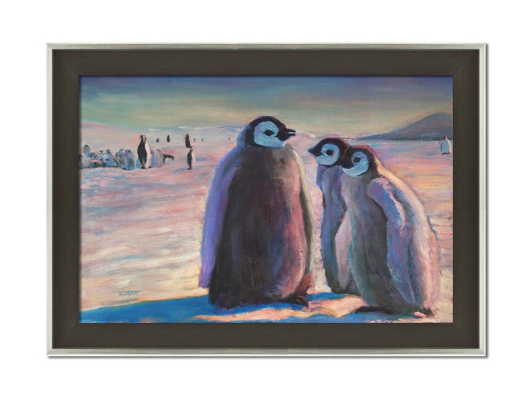 A painting of three young penguins, their colony in the background standing on the icy landscape. Printed on canvas and framed.