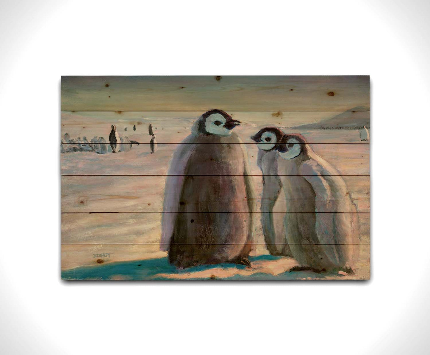 A painting of three young penguins, their colony in the background standing on the icy landscape. Printed on a wood pallet.