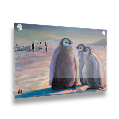 A painting of three young penguins, their colony in the background standing on the icy landscape. Printed on acrylic.