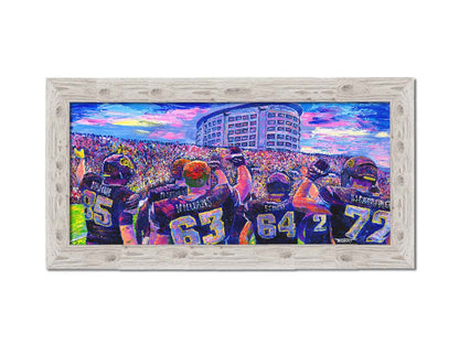 A painting of the Iowa Hawkeyes football team from behind, waving at the massive crowd of fans in front of them. Printed on canvas and framed.